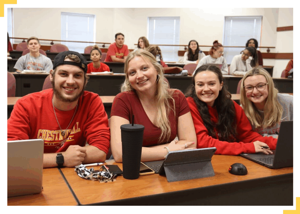 group of students smiling at camera at lunch table