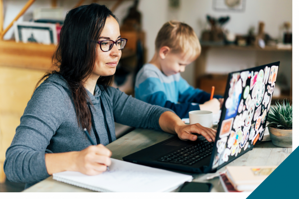 mom on computer next to kid